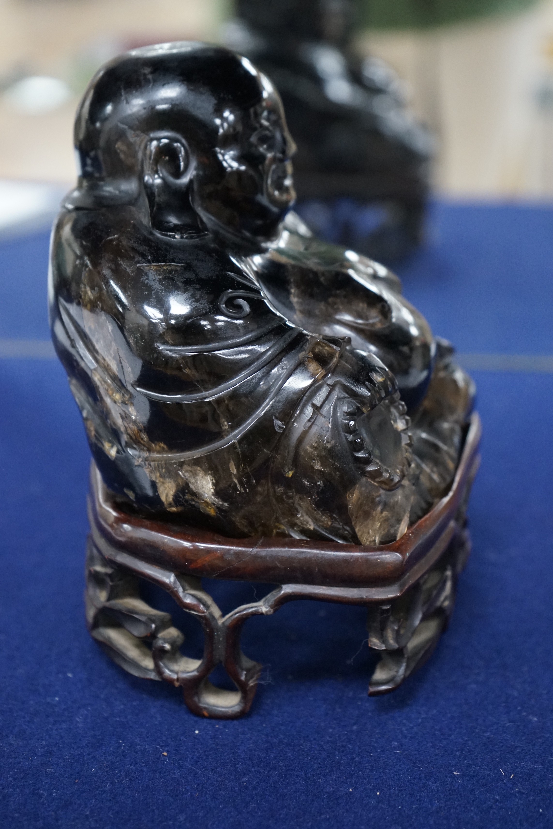 A large Chinese smoky quartz figure of Budai, 17cm tall including wood stand